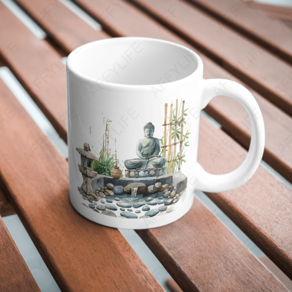 A white mug on a wooden table featuring a serene spring garden art design with a Buddha statue, bamboo, and pebbles. The watercolor PNG print evokes relaxation and harmony, perfecting the decor.
