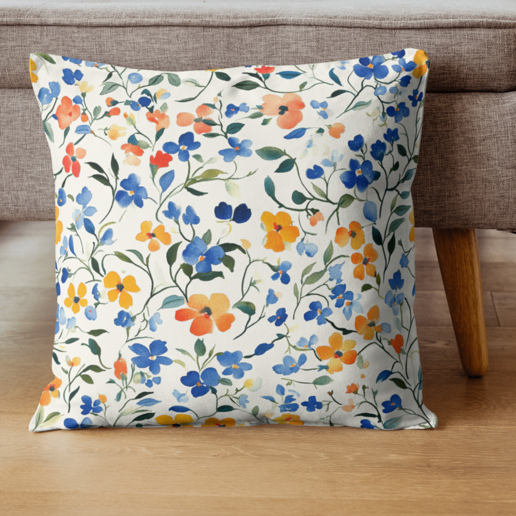 A floral cushion with blue and yellow patterns from the Spring Watercolor Seamless Patterns collection, placed on the floor in front of a sofa.
