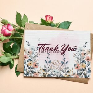 A thank-you card with pink roses and a floral design was placed in a brown envelope. The text reads "Thank You for Your Order" in elegant script.