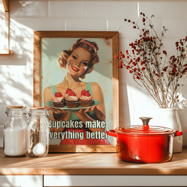 A 1950s Poster of a smiling woman holding cupcakes with the text "Cupcakes make everything better" framed on a kitchen counter. Nearby, glass jars, a red pot, and dried flowers enhance the cozy, nostalgic ambiance.