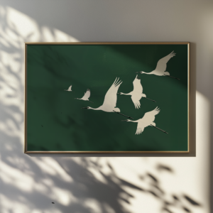 Framed Japandi Wall Art depicting white cranes in flight against a dark green background. Soft shadows and natural light enhance the serene and elegant atmosphere.