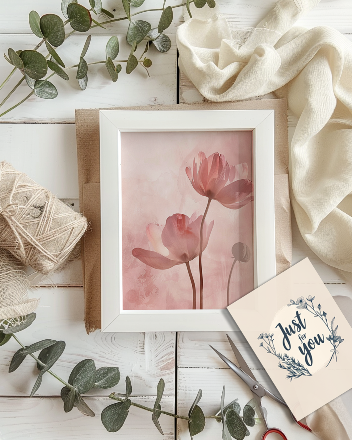 Flat lay of a kraft-wrapped white picture frame with a blank canvas, eucalyptus, string, scissors, and a gift tag labeled “Just for you” — styled in cozy Scandinavian minimal design, perfect for a printable poster gift