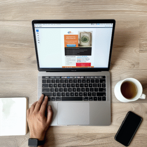 Laptop screen displays a page about Japandi tree ring wall art. A cup of tea, smartphone, and notebook rest nearby on a wooden desk. How to use a digital download from Etsy.