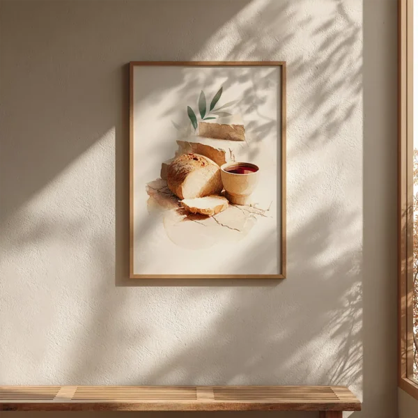 Framed Christian Communion Wall Art of rustic bread, a cup of wine, and green leaves on a textured surface. Sunlight casts soft wall shadows.
