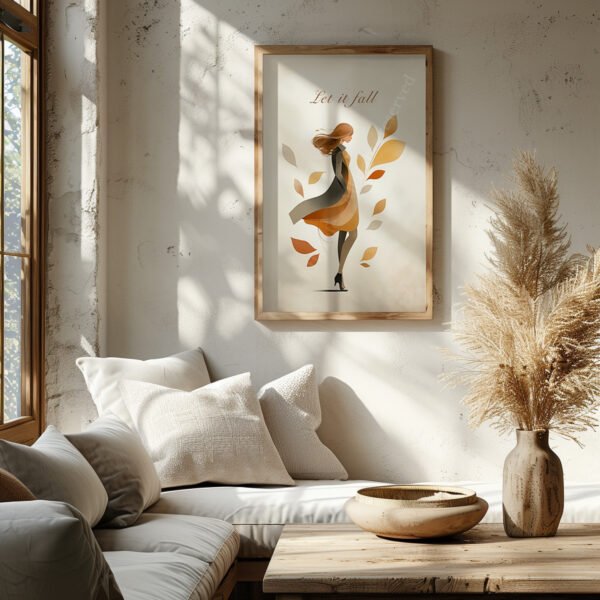 Framed Autumn Girl Wall Art featuring a woman with falling leaves titled “Let it fall.” Displayed in a sunlit room with pampas grass and neutral cushions.