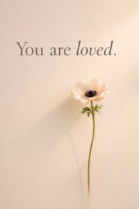 Minimalist Christian wall art with a single white flower on a soft beige background and the text “You are loved”