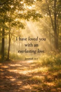 Sunlight filtering through lush green trees onto a forest path with the quote “I have loved you with an everlasting love” Jeremiah 31:3, creating a peaceful natural scene.